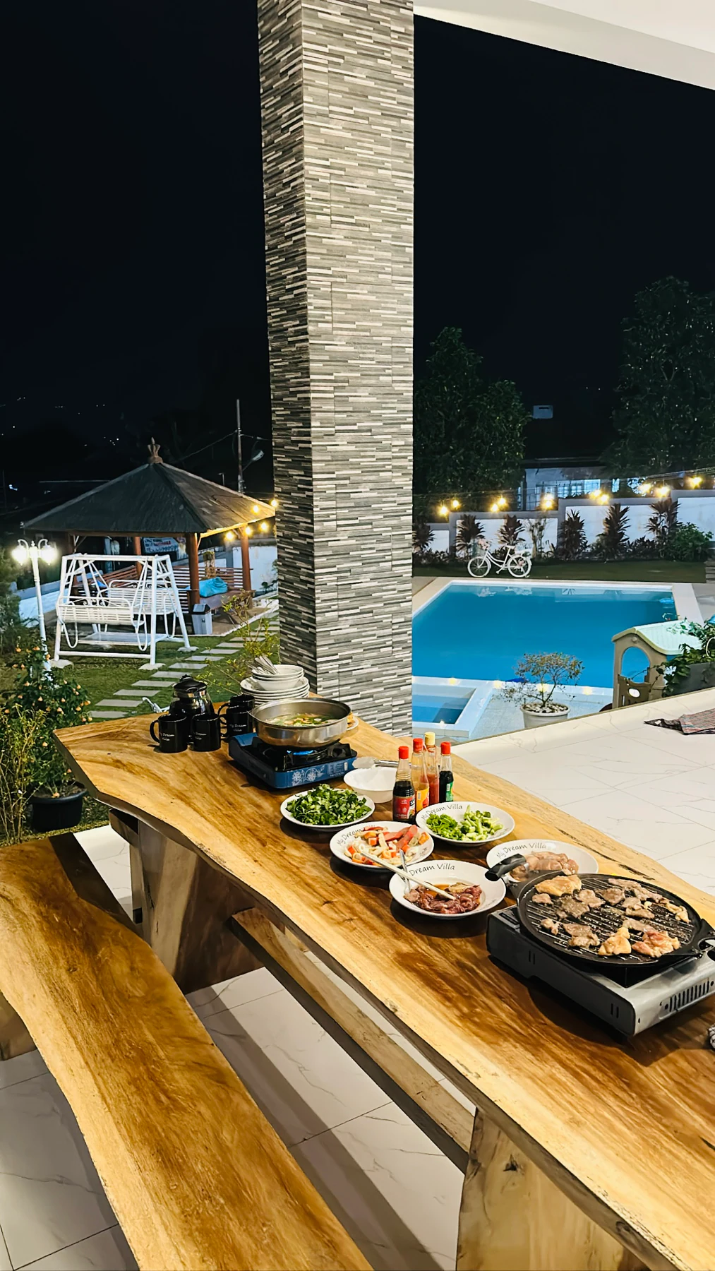 Area makan dan alat BBQ portable gas My Dream Villa pada malam hari